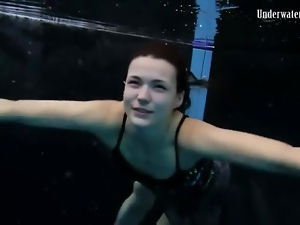 Beautiful girl swims and smiles underwater