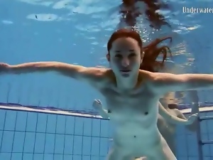 Three girls in bikinis swim and strip in pool