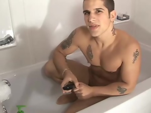 Tattooed solo guy jerking off dick in bathtub